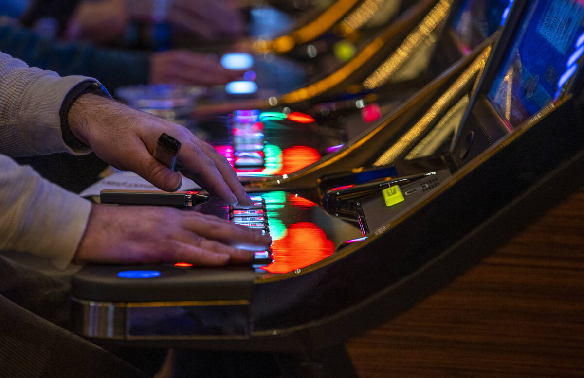A guest plays a slot machine with others nearby at Red Rock Casino on Tuesday, Dec. 26, 2021, i ...
