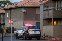 Residents look down on a Metro vehicle as officers conduct a homicide investigation at the Sola ...