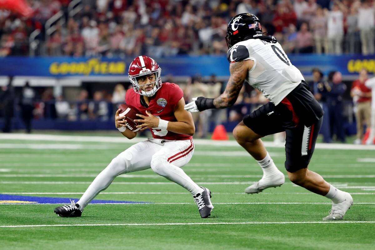 Alabama quarterback Bryce Young (9) tries to avoid Cincinnati's Darrian Beavers (0) during the ...