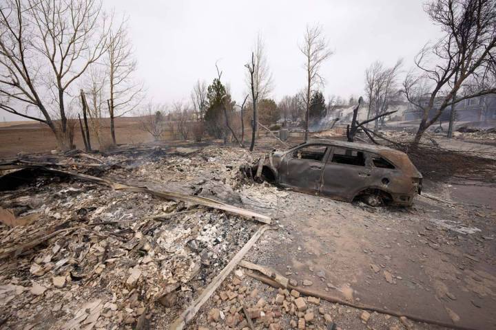 Debris surround the remains of homes burned by wildfires after they ripped through a developmen ...