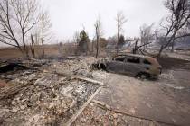 Debris surround the remains of homes burned by wildfires after they ripped through a developmen ...