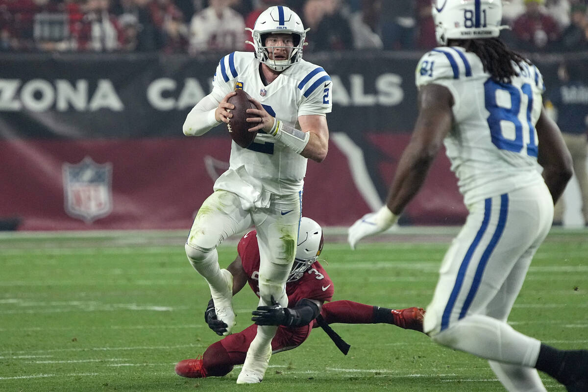 Indianapolis Colts quarterback Carson Wentz (2) is tripped up by Arizona Cardinals safety Budda ...