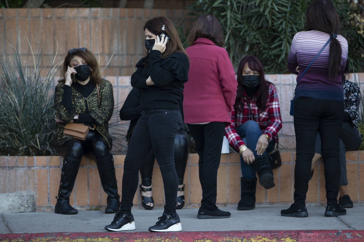 People wait outside of Meadows Mall in Las Vegas as police officers investigate the scene of a ...