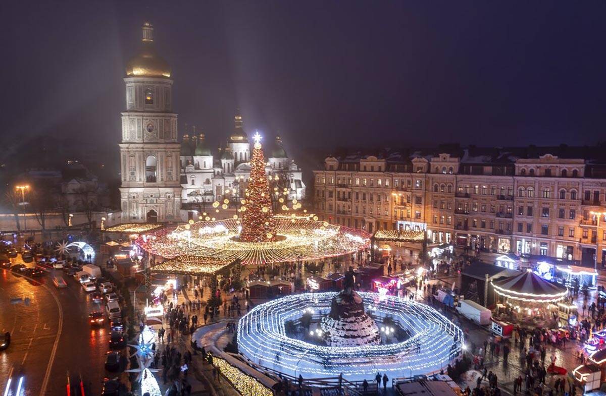 Crowds of people celebrate the New Year's Eve at the Christmas tree and the holiday's market wi ...