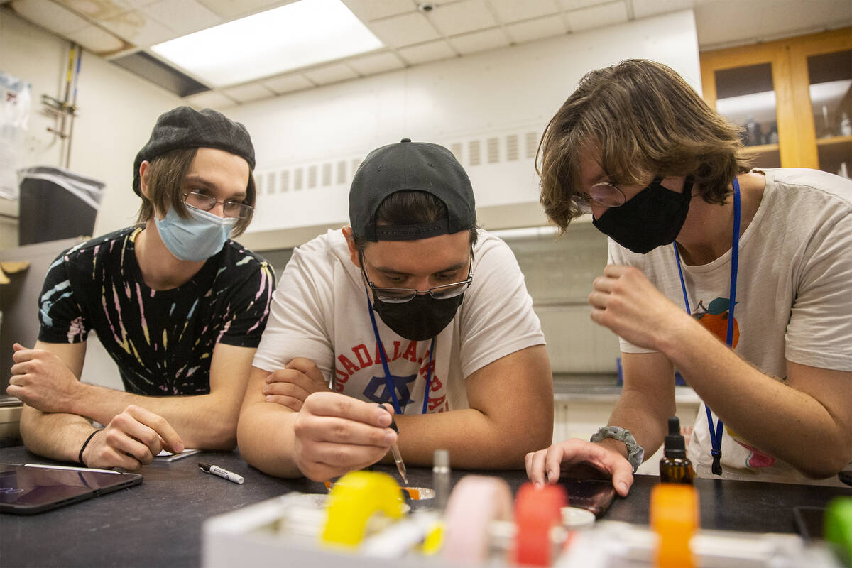 Nevada State College students Adam Hackbarth, left, Zimri Mena and Kendrick Seeber test soil to ...