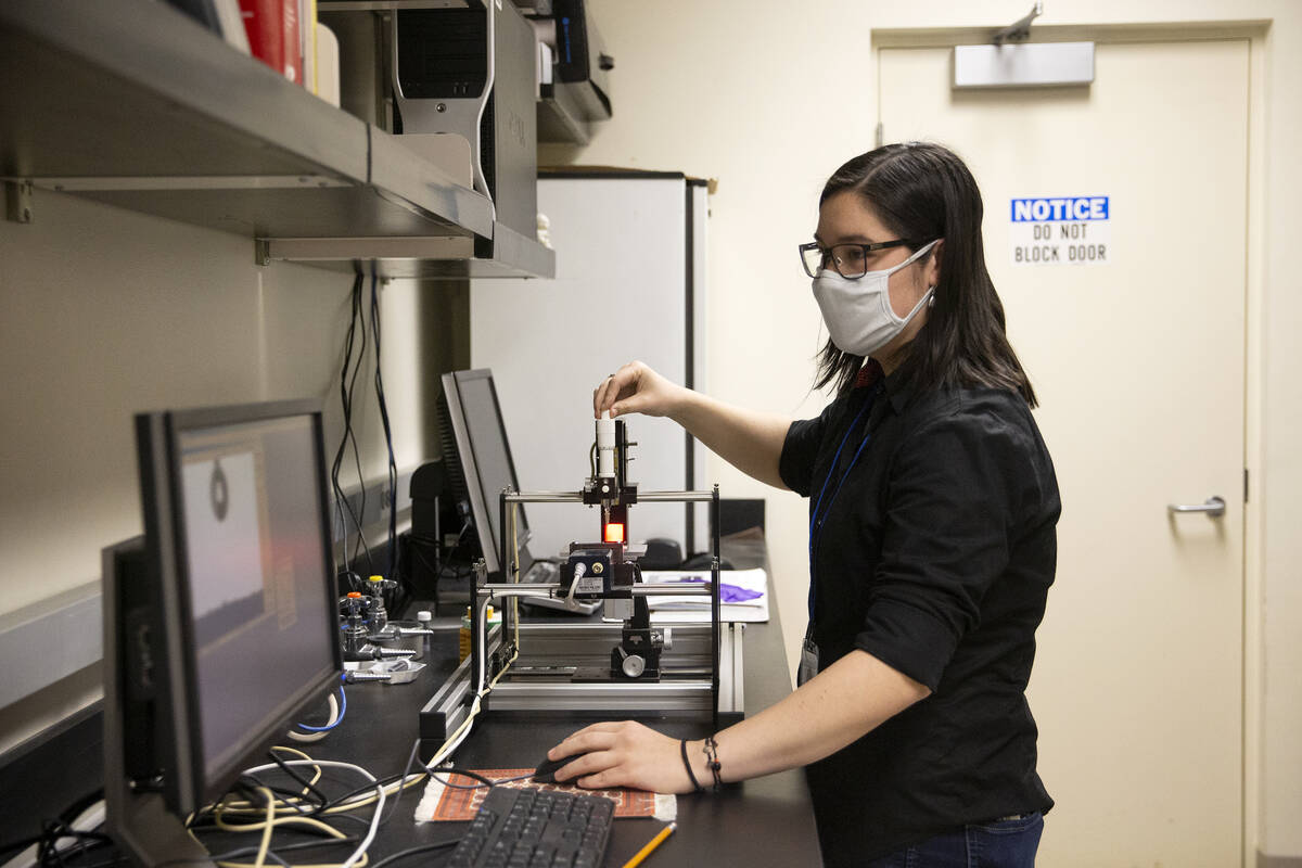 Shelby Inouye, an environmental resource sciences student at Nevada State College, uses a conta ...