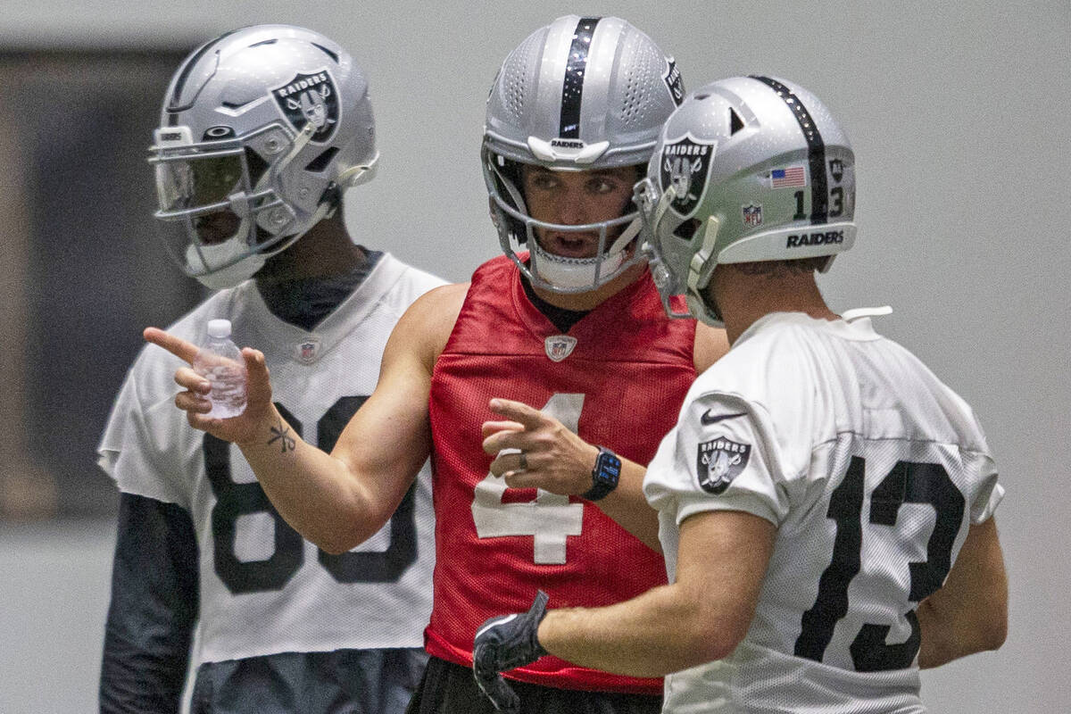 Raiders quarterback Derek Carr (4) talks to Raiders wide receiver Hunter Renfrow (13) during pr ...