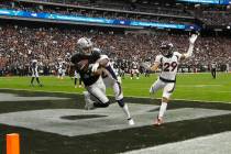 Raiders wide receiver Hunter Renfrow (13) scores a touchdown under pressure from Denver Broncos ...