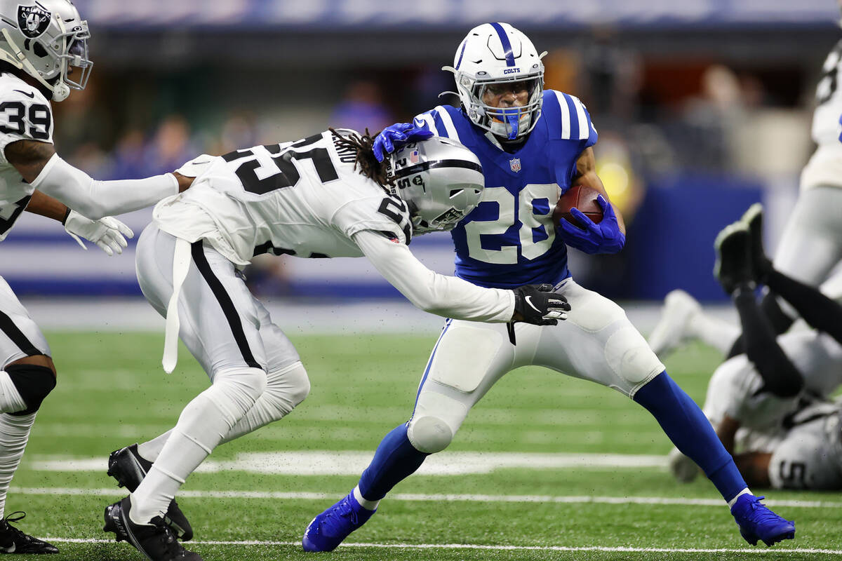 Raiders free safety Trevon Moehrig (25) tackles Indianapolis Colts running back Jonathan Taylor ...