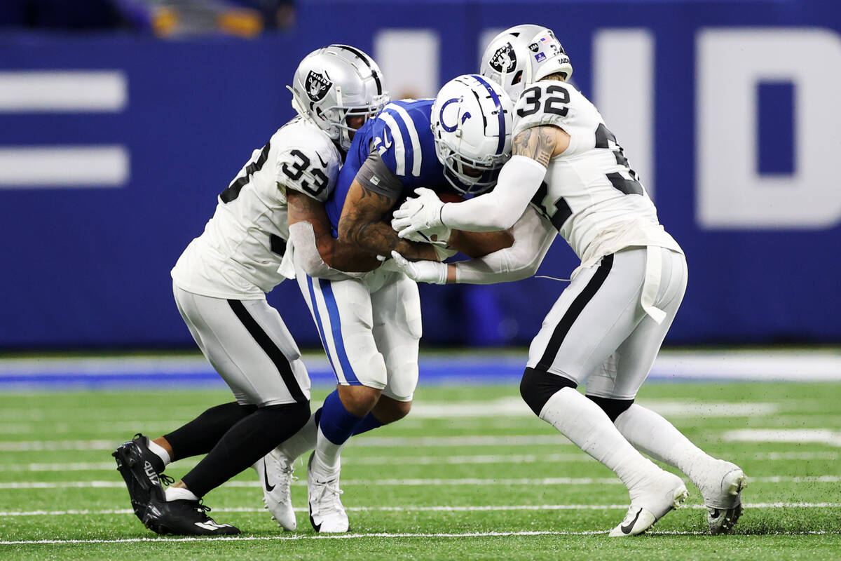 Raiders safety Roderic Teamer (33) and defensive back Dallin Leavitt (32) tackle Indianapolis C ...