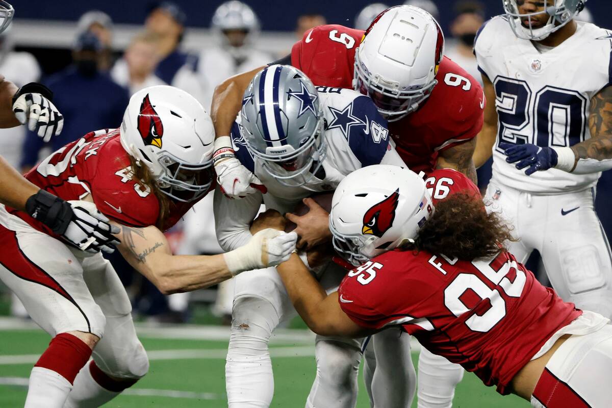 Dallas Cowboys quarterback Dak Prescott (4) is wrapped up by Arizona Cardinals' Dennis Gardeck ...
