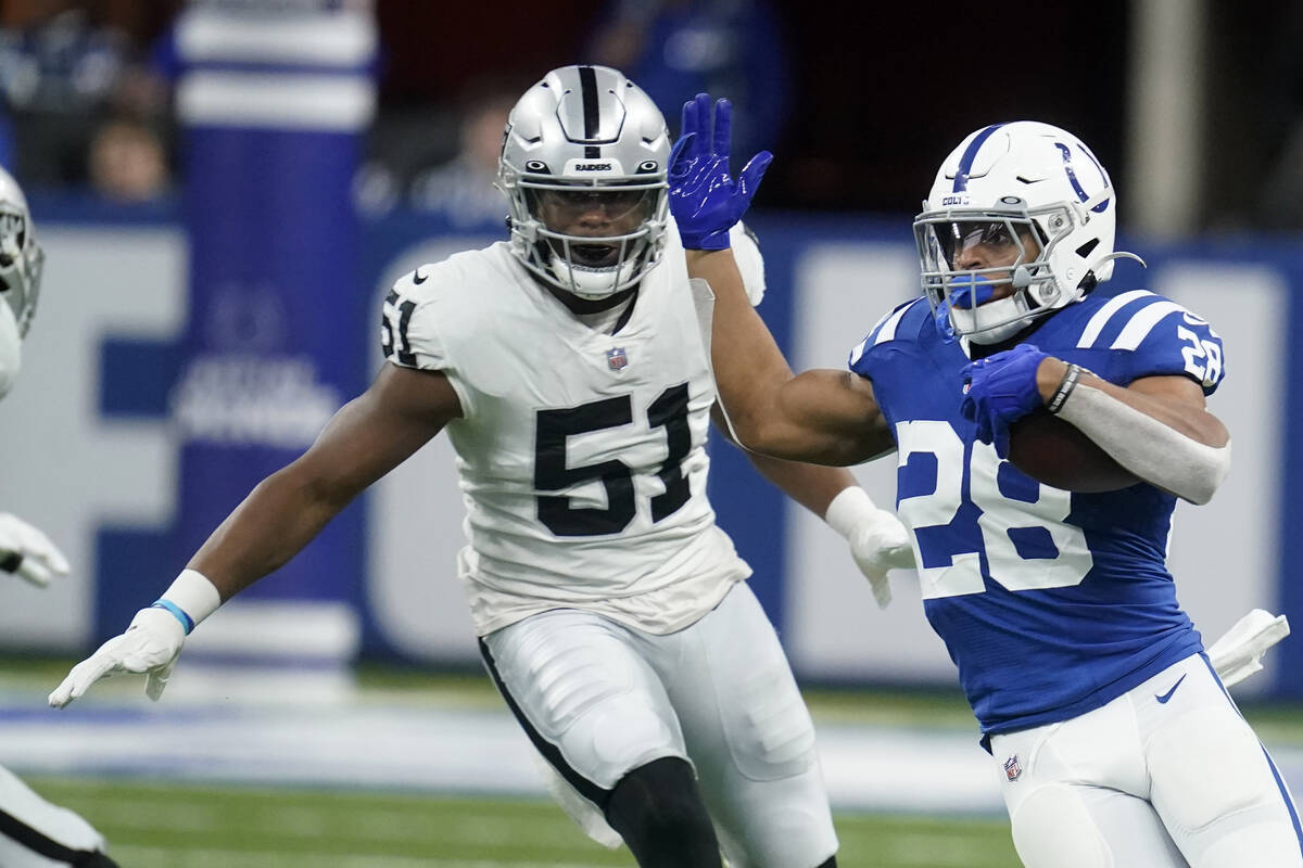Indianapolis Colts running back Jonathan Taylor (28) runs from Las Vegas Raiders defensive end ...
