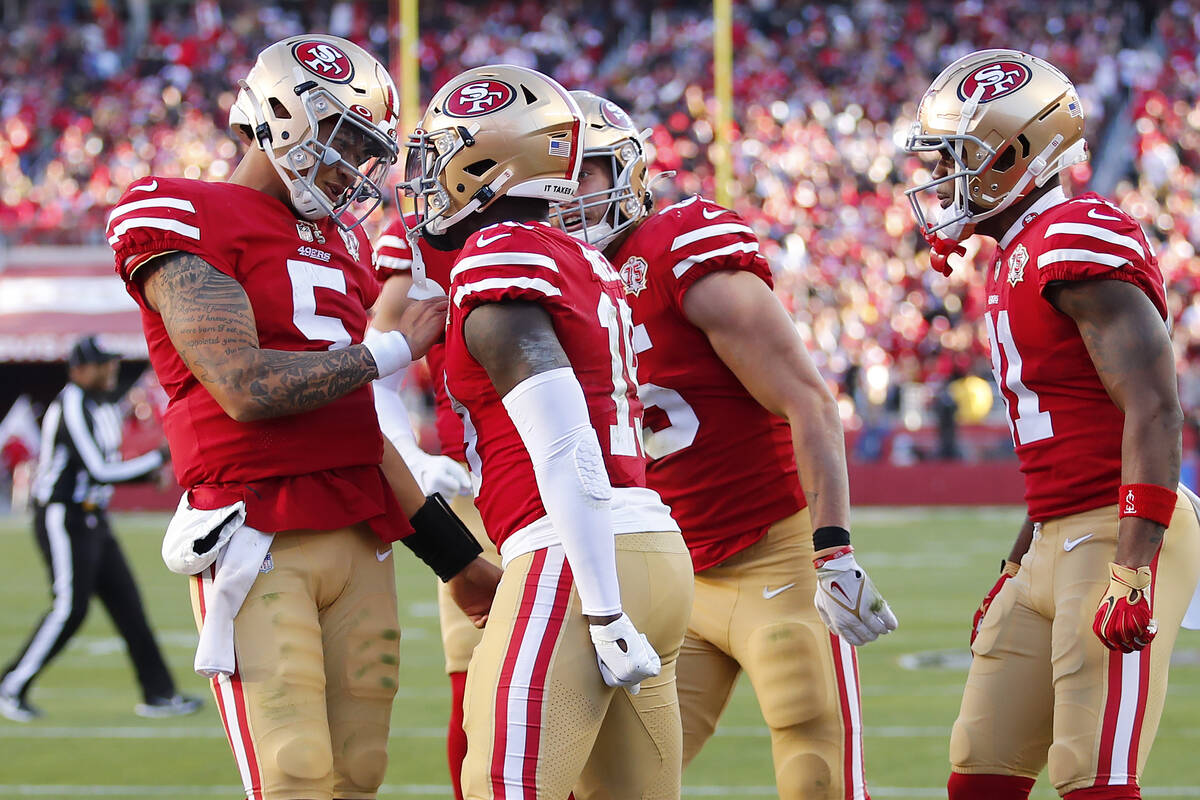 San Francisco 49ers quarterback Trey Lance, left, celebrates after throwing a touchdown pass to ...