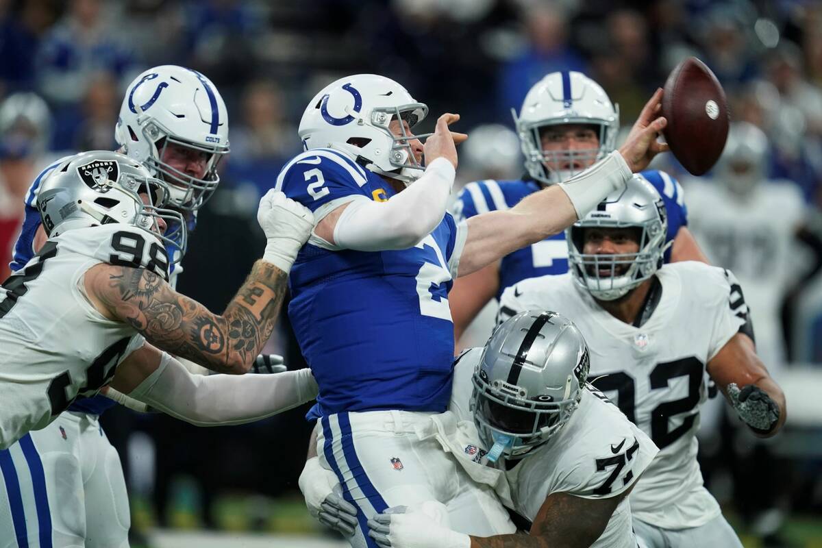 Indianapolis Colts quarterback Carson Wentz (2) passes the ball as he is hit by Las Vegas Raide ...