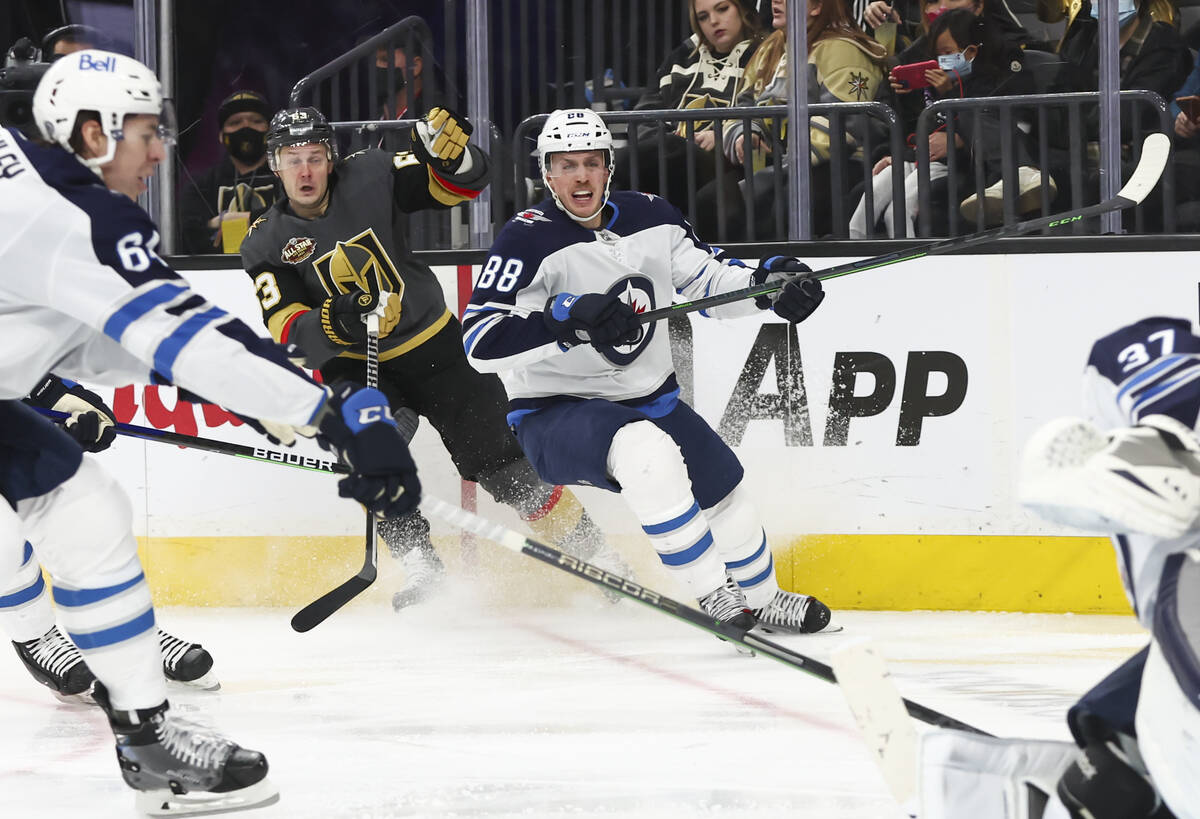 Golden Knights right wing Evgenii Dadonov (63) and Winnipeg Jets defenseman Nate Schmidt (88) w ...