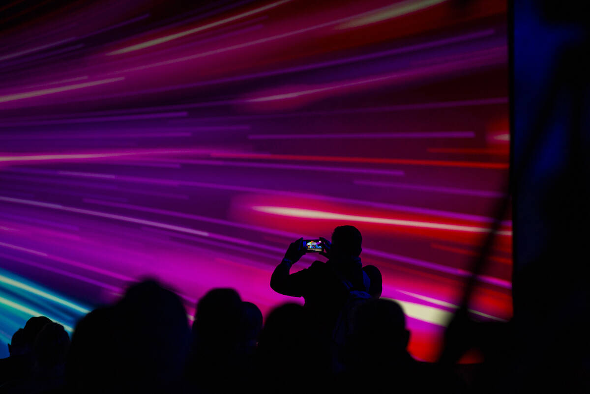 An attendee takes a picture during a keynote session at CES at The Venetian Expo on Wednesday, ...