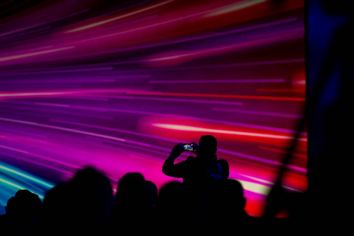 An attendee takes a picture during a keynote session at CES at The Venetian Expo on Wednesday, ...