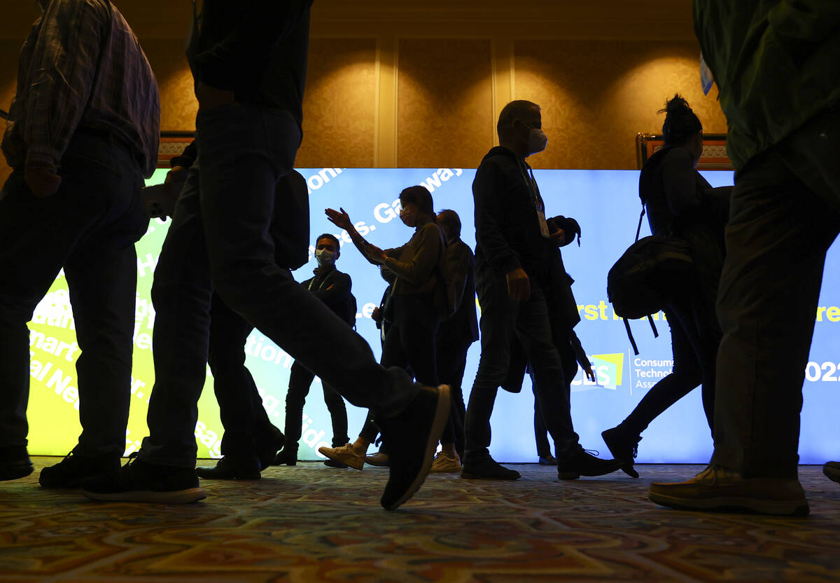 Attendees pass by during CES at The Venetian Expo on Wednesday, Jan. 5, 2022, in Las Vegas. (Ch ...