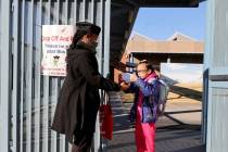 Monica Porter prepares a mask for first grader Dymond Chandler at Williams Elementary in Las Ve ...