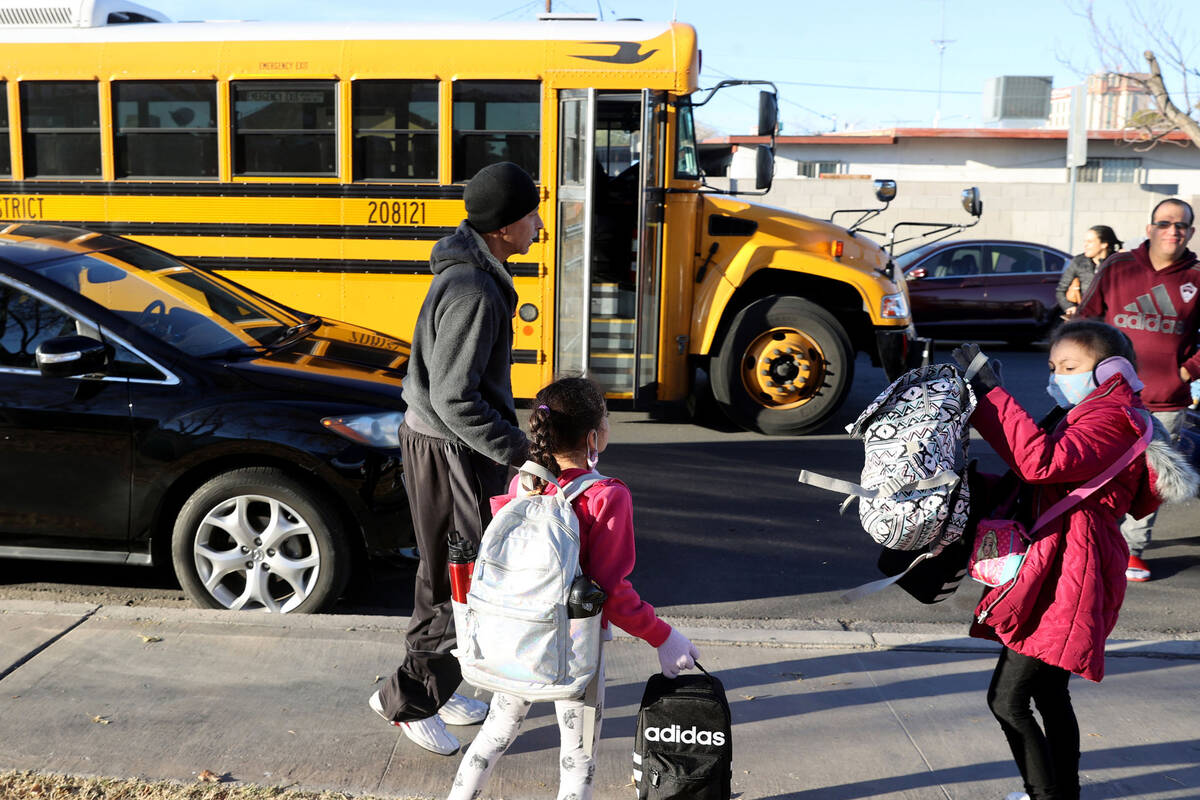 Juan Campos gets his daughter Damaris, 8 right and Diana, 7 ready for the bus on the first day ...