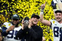 FILE - Michigan coach Jim Harbaugh celebrates with the team after the Big Ten championship NCAA ...