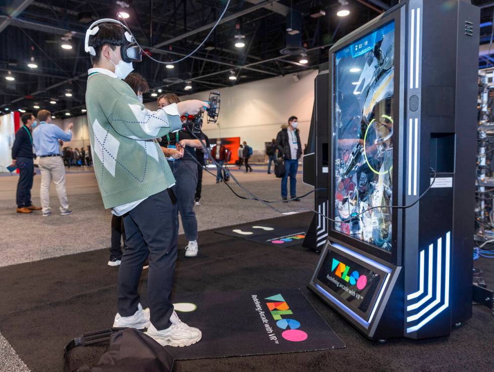 Attendee Kwanghyun Go plays a shooting game with the use of a VRLCO VR game system during the f ...