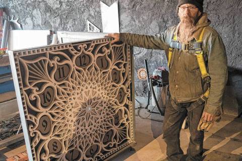James Henninger poses with one of the clock faces he has done for the 25-foot bell tower which ...