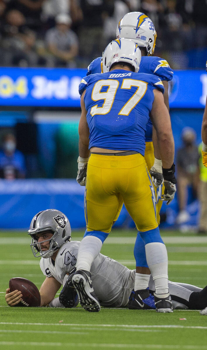 Raiders quarterback Derek Carr (4) stays down after being sacked by Los Angeles Chargers defens ...
