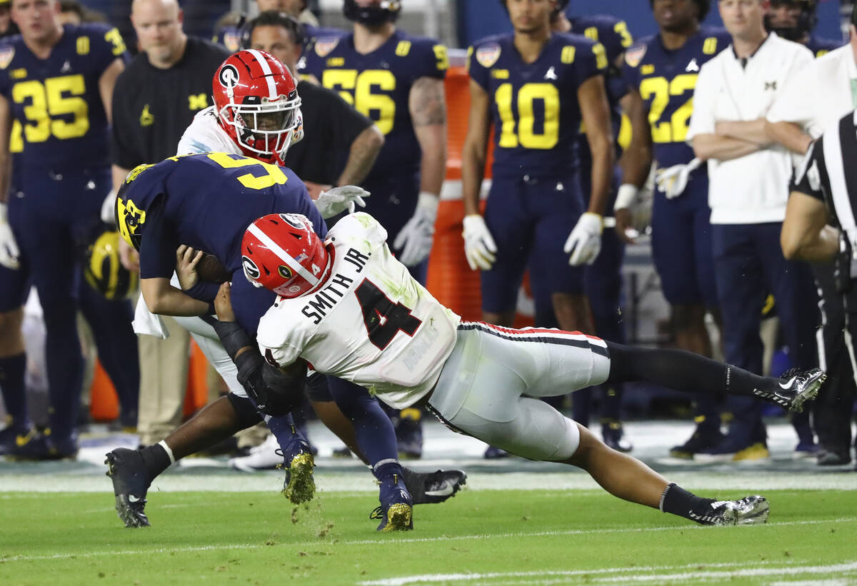 FILE - Georgia linebacker Nolan Smith (4) tackles Michigan quarterback J.J. McCarthy (9) during ...