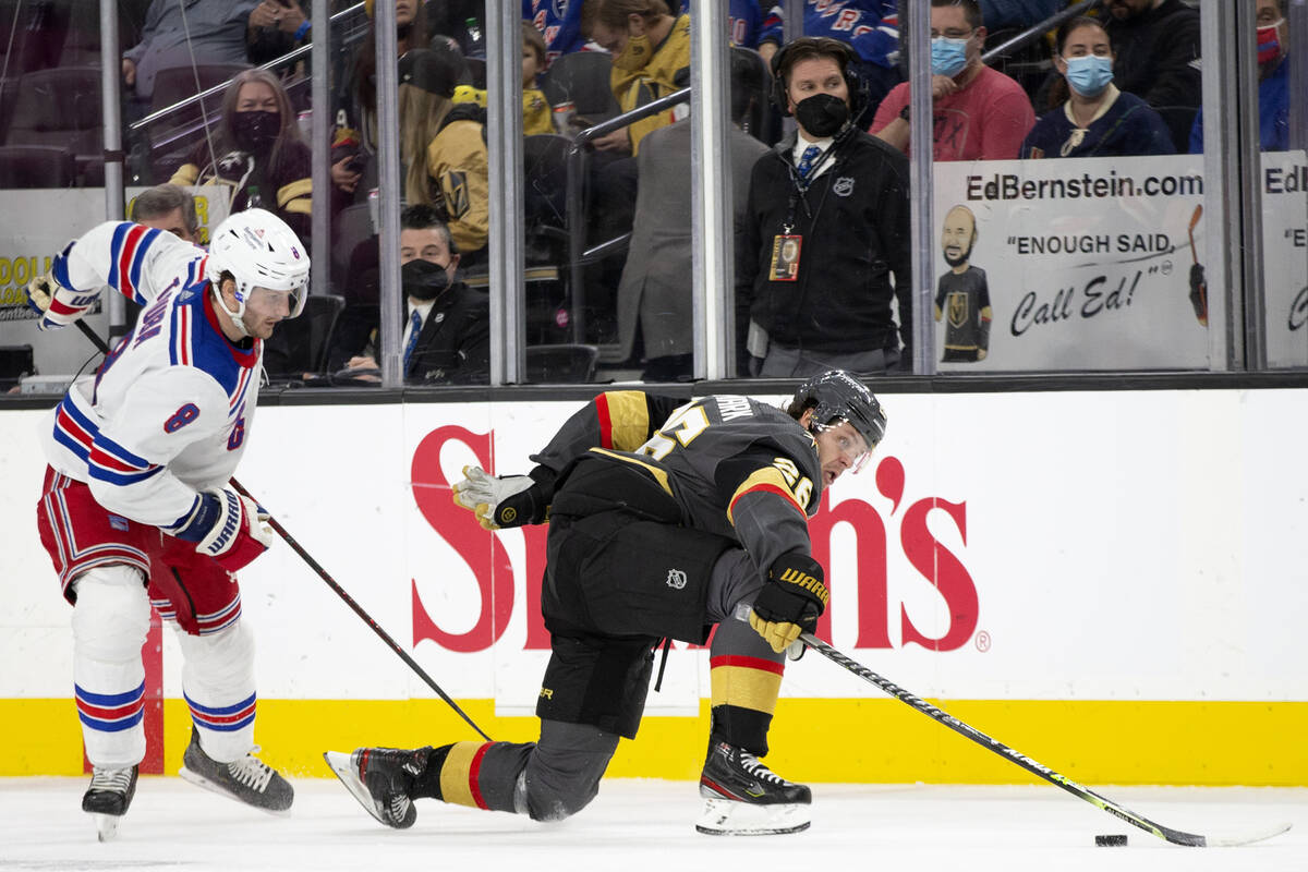 Rangers defenseman Jacob Trouba (8) trips Golden Knights center Mattias Janmark (26) during the ...