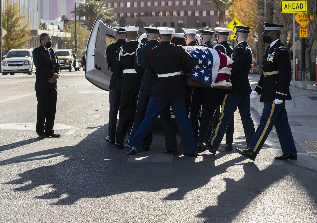 A military honor guard carries the flag-draped casket of former U.S. Sen. Harry Reid out of The ...