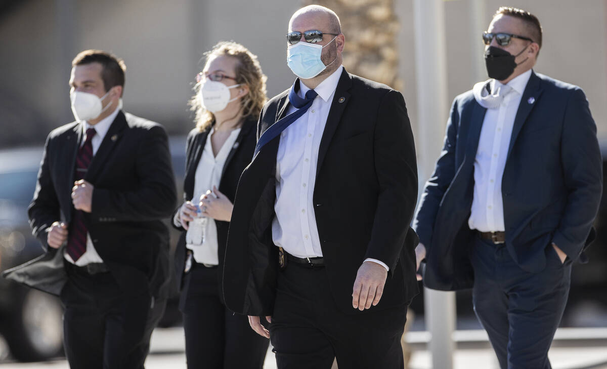 Security details walk the perimeter of The Smith Center before the start of a memorial service ...