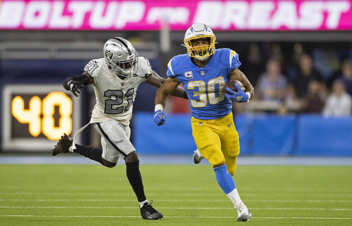 Los Angeles Chargers running back Austin Ekeler (30) breaks off a big run past Raiders cornerba ...
