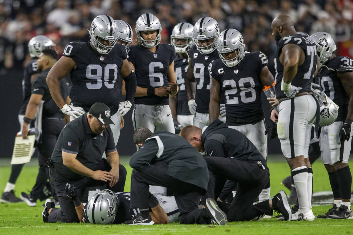 Raiders fullback Alec Ingold (45) is looked at by trainers as his teammates look on after being ...