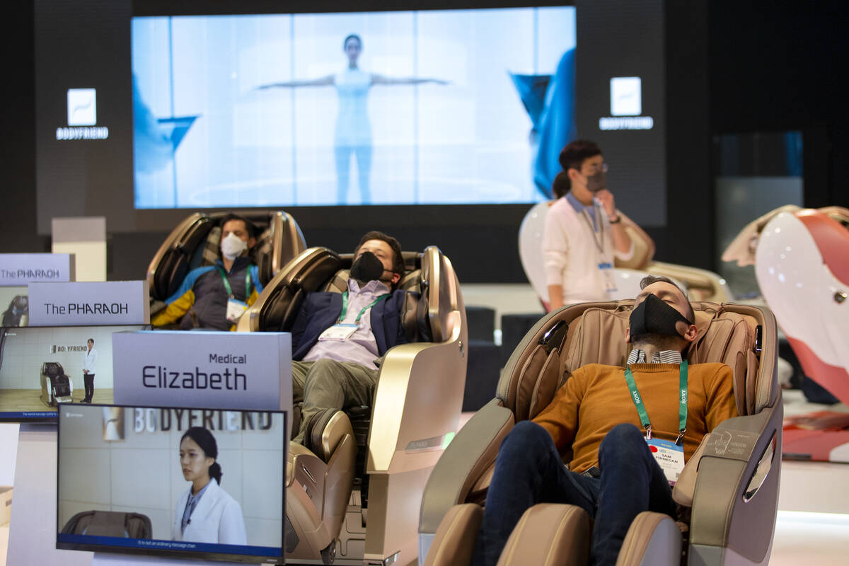 Convention attendees test massage chairs by South Korean health tech company Bodyfriend during ...