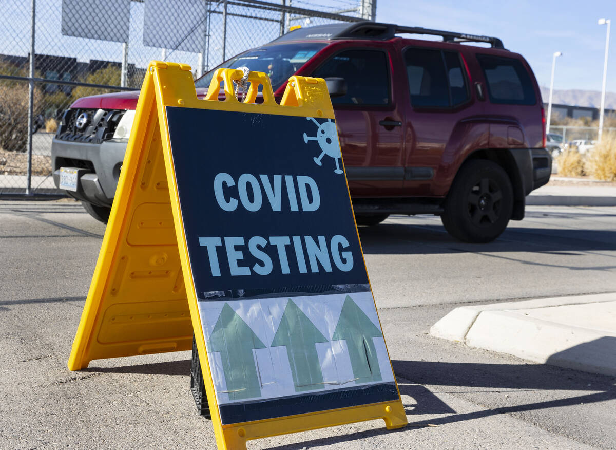 An employee at the Clark County School District drives past a COVID testing sign outside of CCS ...