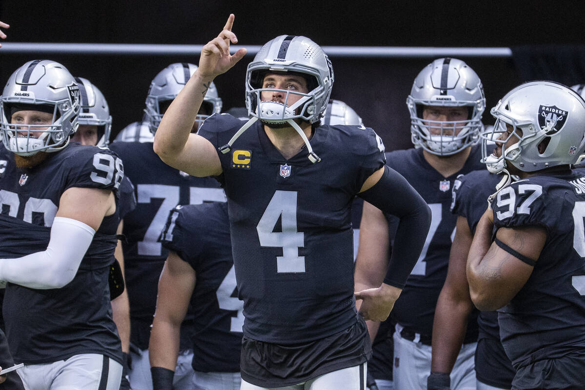 Raiders quarterback Derek Carr (4) points to the heavens when entering the field with teammates ...