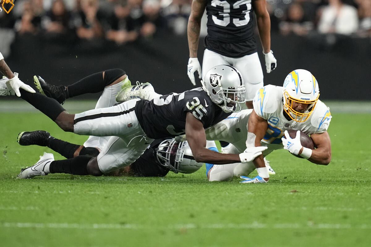 Los Angeles Chargers running back Austin Ekeler (30) is tackled after catching a deflected pass ...