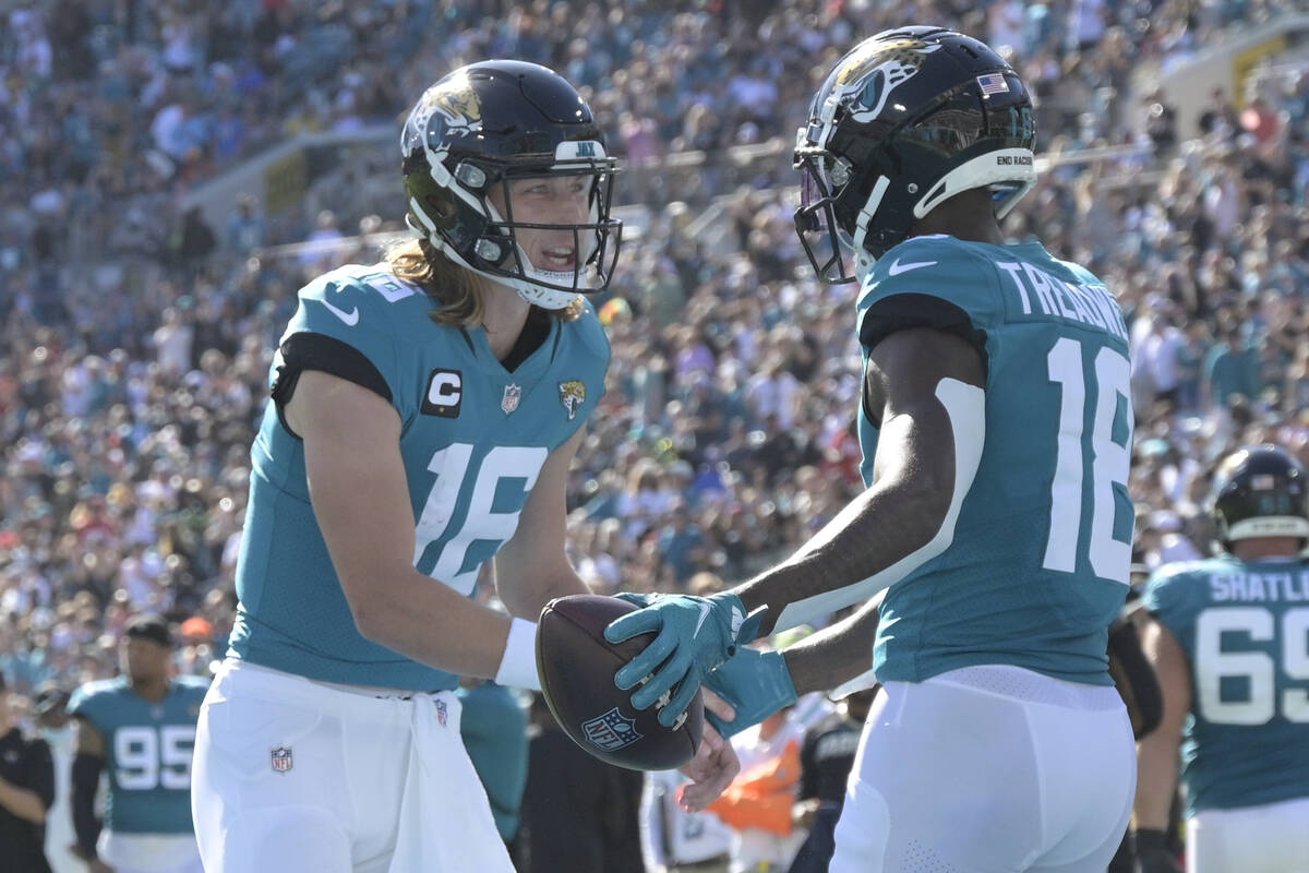 Jacksonville Jaguars quarterback Trevor Lawrence, left, and Jacksonville Jaguars wide receiver ...
