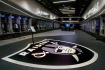 A large logo is painted on the floor in the expansive locker room within the Las Vegas Raiders ...