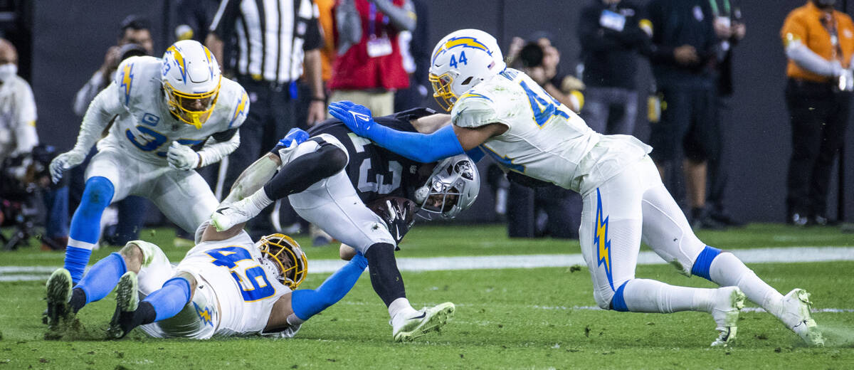 Raiders wide receiver Hunter Renfrow (13) is team tackled by Los Angeles Chargers outside lineb ...