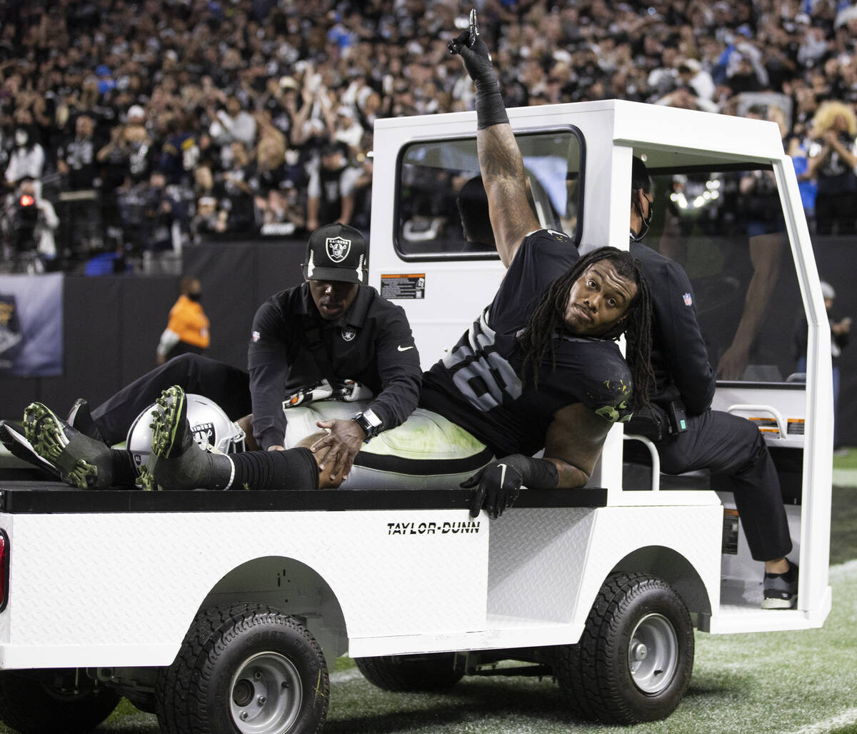 Raiders defensive tackle Darius Philon (96) waves to the crowd as he’s carted off in the ...