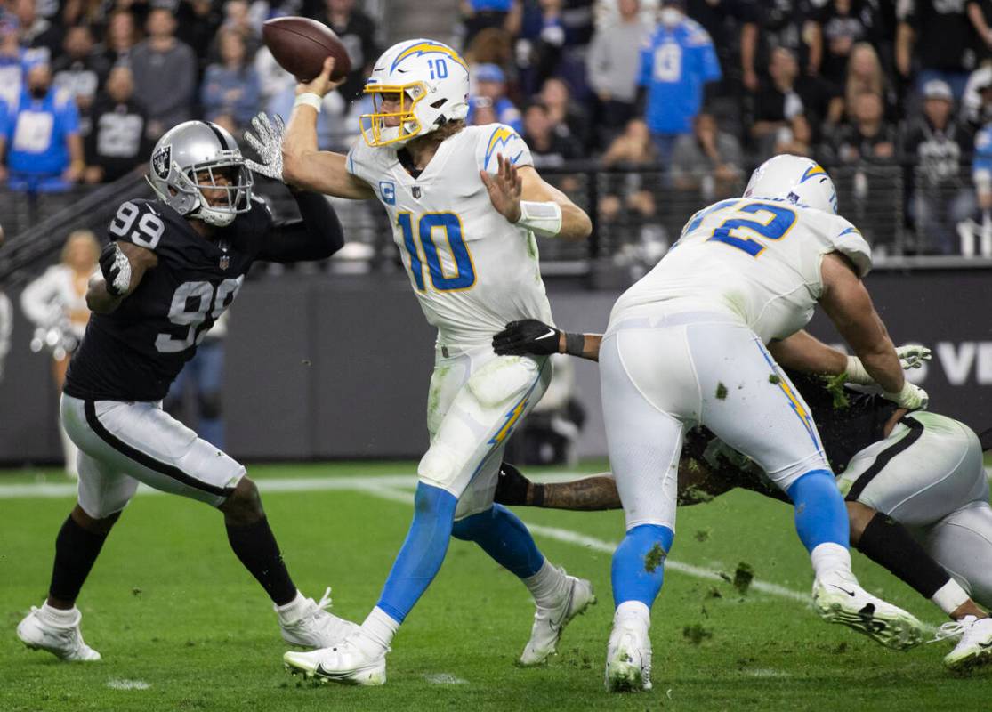 Los Angeles Chargers quarterback Justin Herbert (10) is pressured by Raiders defensive end Clel ...
