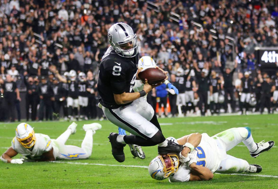 Raiders quarterback Marcus Mariota (8) is tackled Los Angeles Chargers safety Alohi Gilman (32) ...