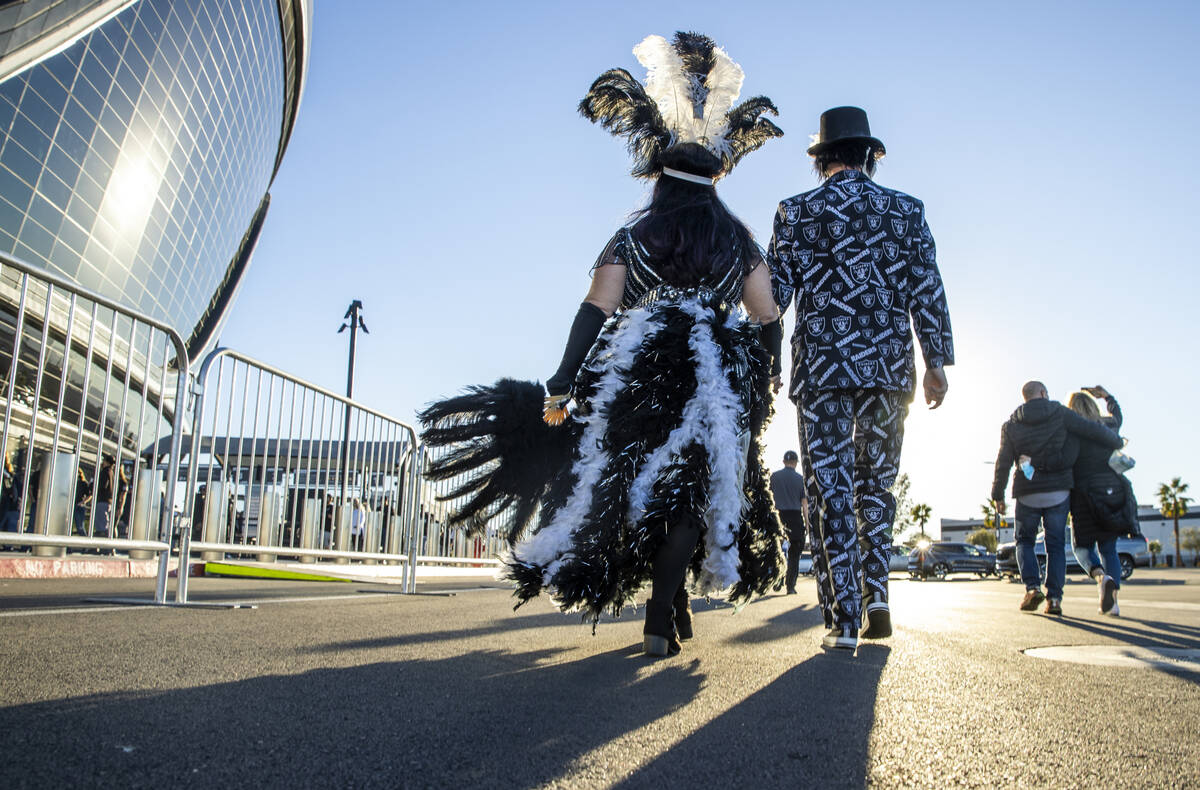Costumed fans walk towards an entrance before the first half of an NFL game at Allegiant Stadiu ...