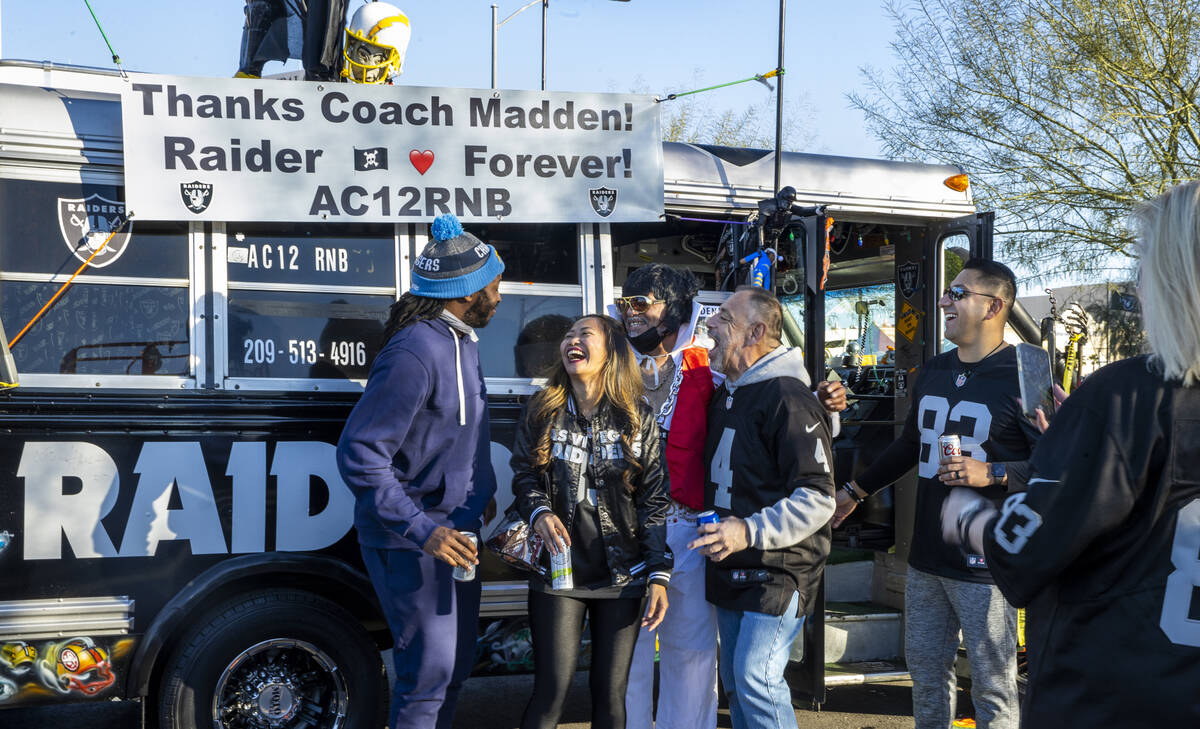Fans gather for a photo beneath a sign thanks former Raiders coach John Madden in the tailgate ...