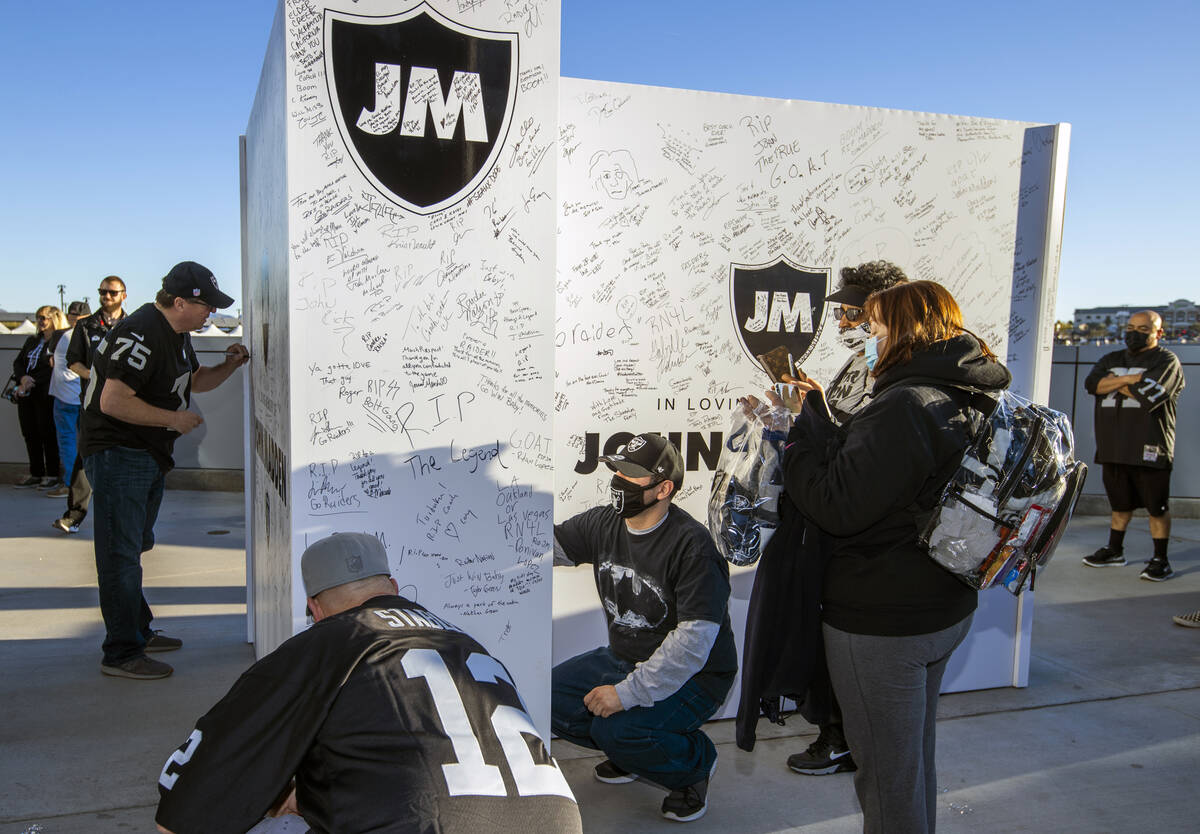 Fans sign messages on a memorial wall to former Raiders coach John Madden before the first half ...