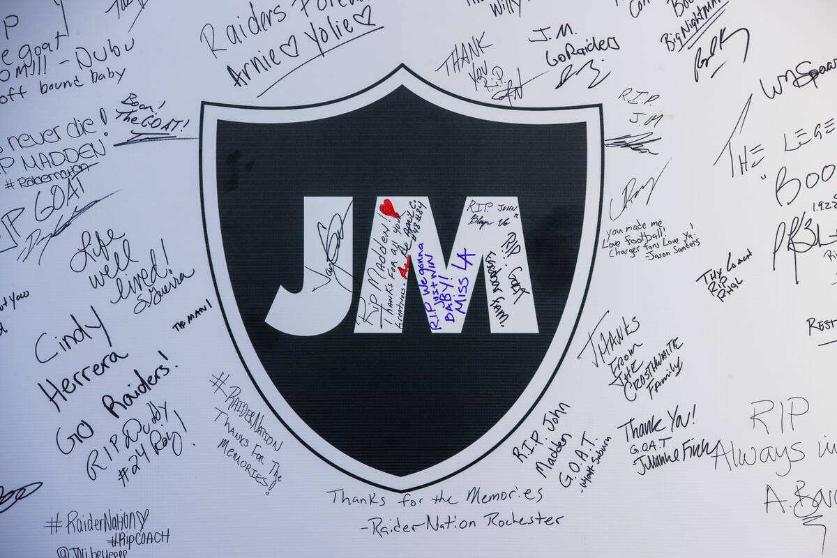 Fans sign messages on a memorial wall to former Raiders coach John Madden before the first half ...