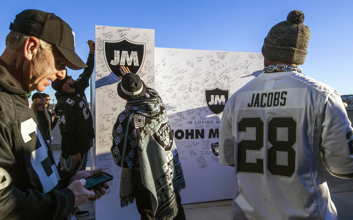Fans sign messages on a memorial wall to former Raiders coach John Madden before the first half ...