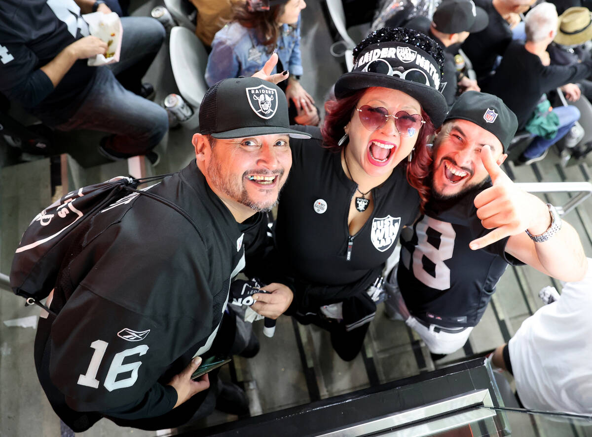 Claudio Campas, from left, Sheila Bradley and Lalo Cruz, all of Phoenix, during halftime as the ...